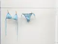 Costume da bagno azzurro appeso ad asciugare. Facile da lavare in lavatrice, pronto per la prossima avventura al mare.