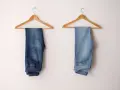 Due paia di jeans appesi a grucce: uno scuro, l'altro chiaro, per mostrare come sbiadire i jeans.