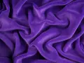 Ondeggiante velour tessuto viola, morbido e invitante, con pieghe profonde che creano un gioco di luci e ombre.
