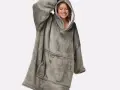 Donna sorridente indossa una coperta con cappuccio grigia, realizzata in poliestere, un materiale sintetico caldo e confortevole.
