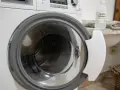 Dettaglio di una lavatrice con oblò aperto, pronto per un ciclo di pulizia con aceto bianco, per una vita media ottimale dell'elettrodomestico.