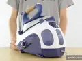 Un primo piano di un ferro da stiro a vapore DeLonghi Vaporella, con la sua base bianca e blu.