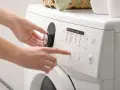 Mani impostano la lavatrice, scegliendo il programma e la velocità di rotazione per capire quanto dura la centrifuga della lavatrice.