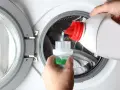 Versando detersivo liquido in un misurino per lavatrice. Ideale per capi delicati, cosa lavare a 20 gradi per preservare i colori.