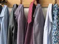 Camicie da uomo con fantasie diverse appese a un attaccapanni. Un promemoria su come lavare le camicie a mano per mantenerle perfette.