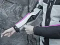 Mani che chiudono la zip di una giacca da moto, pronta per essere lavata in lavatrice.