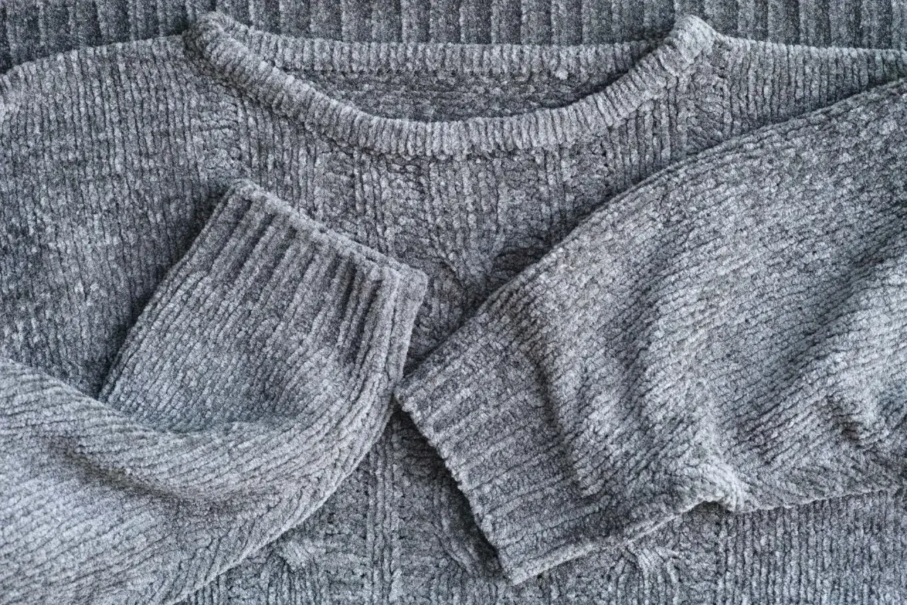 Maglione grigio in morbida lana, con maniche piegate.
