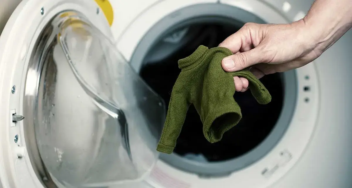 Maglione di viscosa ristretta, rimedi per recuperarlo. Mano che estrae il capo dalla lavatrice.
