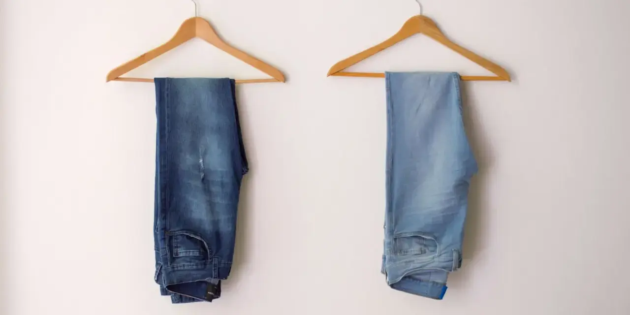 Due paia di jeans appesi a grucce: uno scuro, l'altro chiaro, per mostrare come sbiadire i jeans.