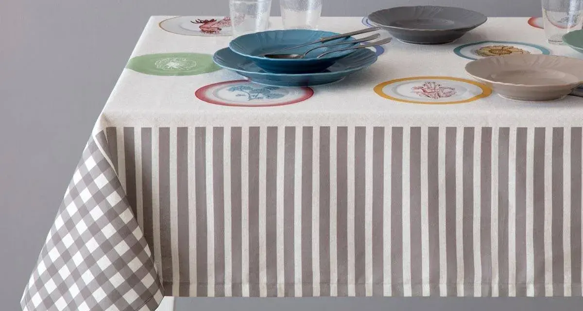 Tovaglia a righe e quadri con piatti colorati. Un'idea per sapere come smacchiare le tovaglie e mantenerle sempre perfette.