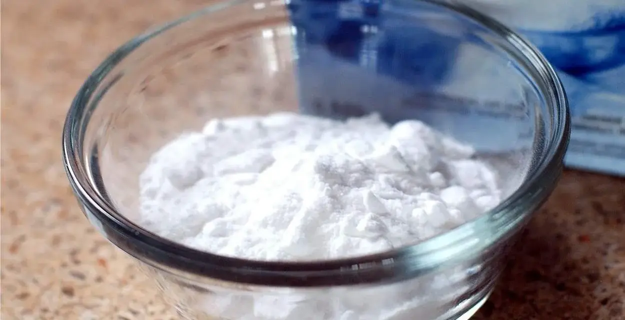 Bicarbonato in una ciotola di vetro, pronto per essere usato sui capi colorati per un bucato più brillante e fresco.