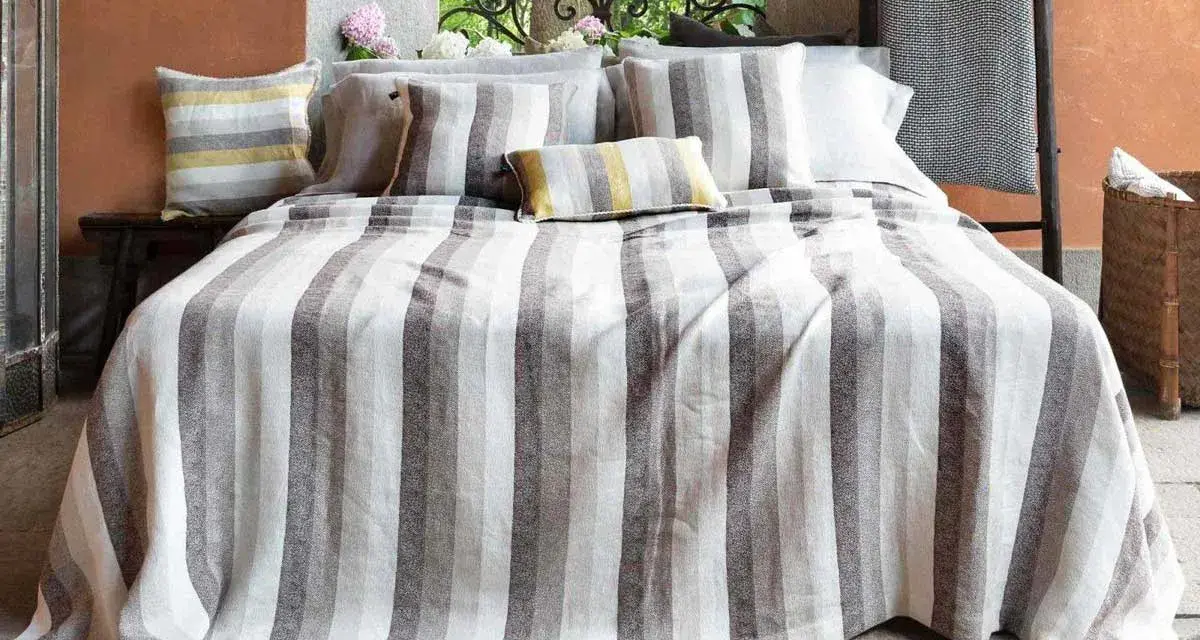 Letti a righe grigie e bianche, con cuscini coordinati. Un tocco di candeggina su lino bianco per un look fresco e moderno.