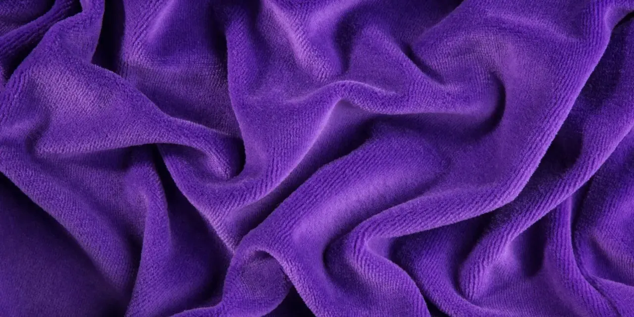 Tessuto di velluto a coste viola, morbido e drappeggiato. Scopri come lavare il velluto a coste per mantenerlo come nuovo.