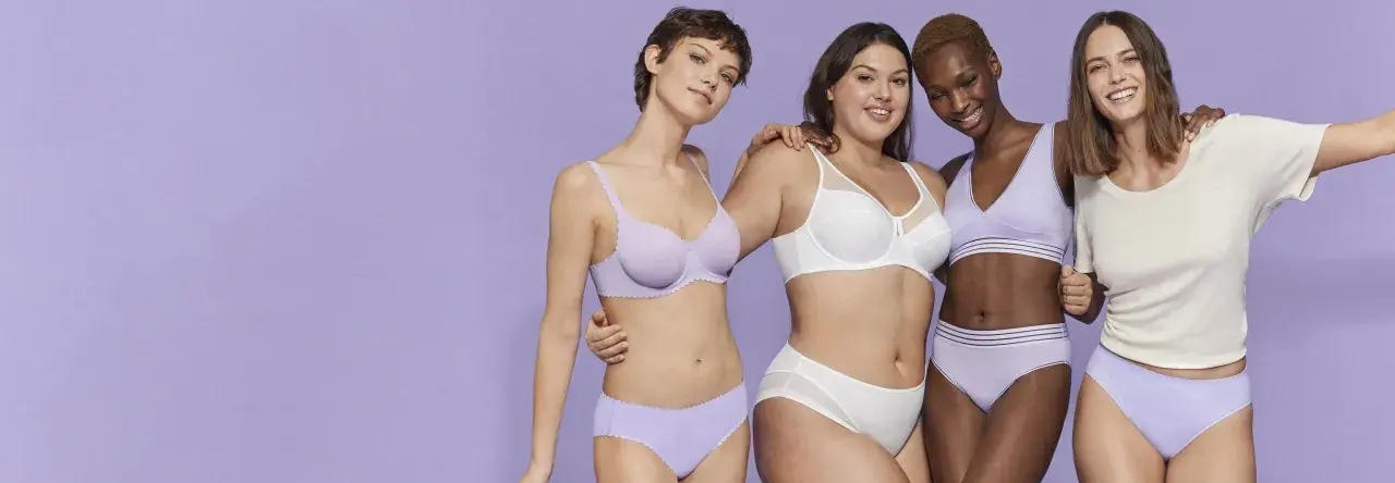 Quattro donne sorridono, indossando intimo color lavanda e bianco. Perfetto per il programma lavatrice per intimo.