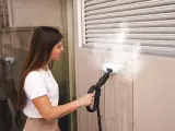 Donna pulisce una parete esterna con una **vaporella Polti**, dimostrando la **manutenzione** efficace contro lo sporco.