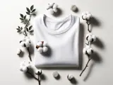 Maglietta bianca in cotone eco, circondata da rametti di cotone e foglie. Perfetta per un lavaggio in lavatrice delicato.