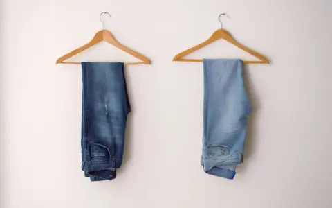 Due paia di jeans appesi a grucce: uno scuro, l'altro chiaro, per mostrare come sbiadire i jeans.