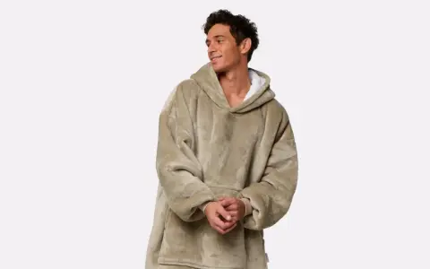Uomo sorridente indossa felpa oversize color sabbia. Per il lavaggio cotone 40 gradi durata ottimale.