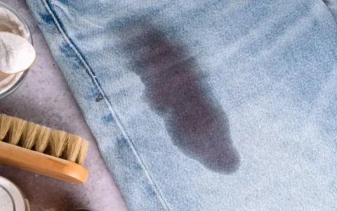 Macchia scura su jeans chiari, con bicarbonato e spazzola. Scopri come togliere il grasso dai jeans con rimedi naturali.