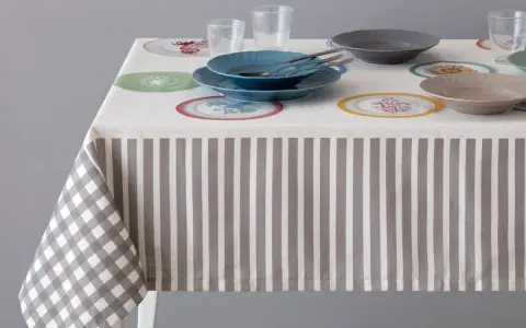 Tovaglia a righe e quadri con piatti colorati. Un'idea per sapere come smacchiare le tovaglie e mantenerle sempre perfette.