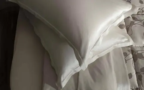 Federa di seta bianca, con un lenzuolo sottostante. Scopri come lavare la seta ingiallita per mantenerla luminosa.