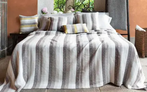 Letti a righe grigie e bianche, con cuscini coordinati. Un tocco di candeggina su lino bianco per un look fresco e moderno.