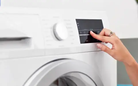 Dito, un dito seleziona l'opzione "lavaggio rapido lavatrice" sul pannello di controllo.
