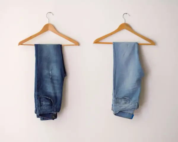 Due paia di jeans appesi a grucce: uno scuro, l'altro chiaro, per mostrare come sbiadire i jeans.