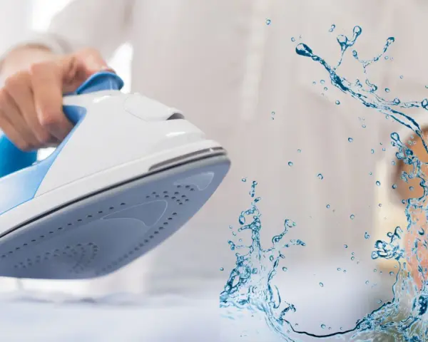 Ferro da stiro con spruzzo d'acqua. L'acqua per ferro da stiro aiuta a eliminare le pieghe dai tessuti.