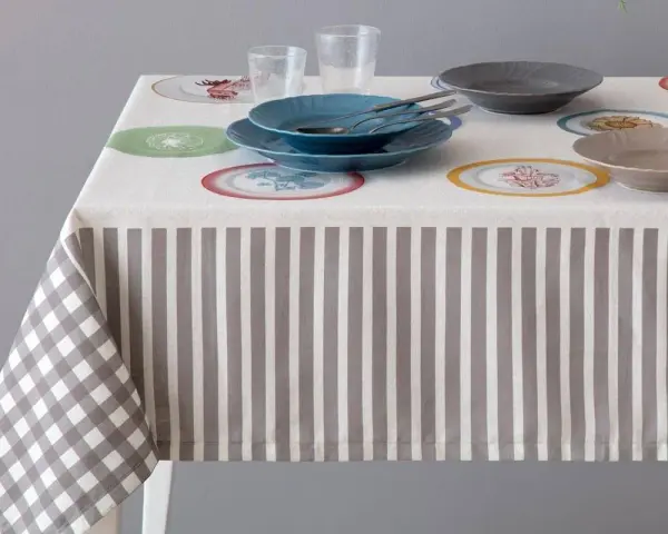 Tovaglia a righe e quadri con piatti colorati. Un'idea per sapere come smacchiare le tovaglie e mantenerle sempre perfette.