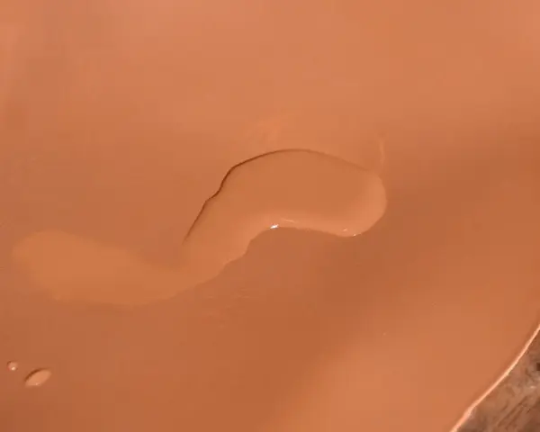 Una goccia d'acqua sola su una borsa di pelle color cuoio.