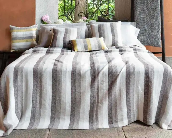 Letti a righe grigie e bianche, con cuscini coordinati. Un tocco di candeggina su lino bianco per un look fresco e moderno.