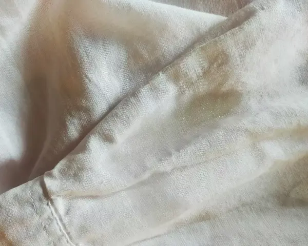 Tessuto di poliestere con macchie d'acqua visibili, che creano un effetto leggermente lucido e irregolare sulla superficie.