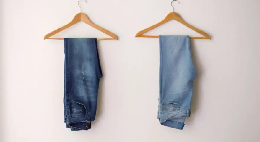 Due paia di jeans appesi a grucce: uno scuro, l'altro chiaro, per mostrare come sbiadire i jeans.