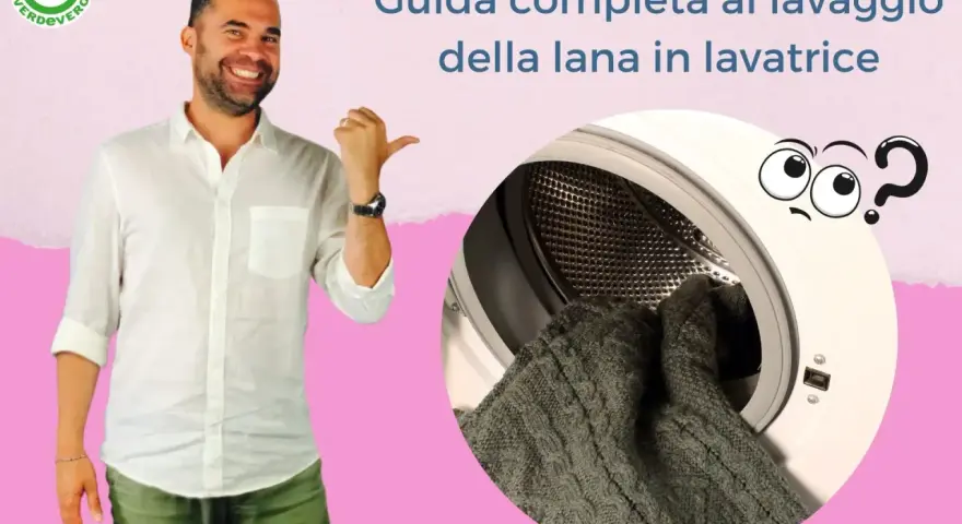 Uomo sorridente indica una lavatrice con dentro un maglione di lana fredda. Guida al lavaggio in lavatrice.