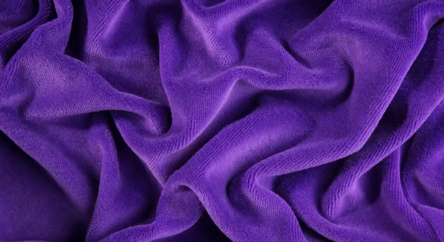 Tessuto di velluto a coste viola, morbido e drappeggiato. Scopri come lavare il velluto a coste per mantenerlo come nuovo.
