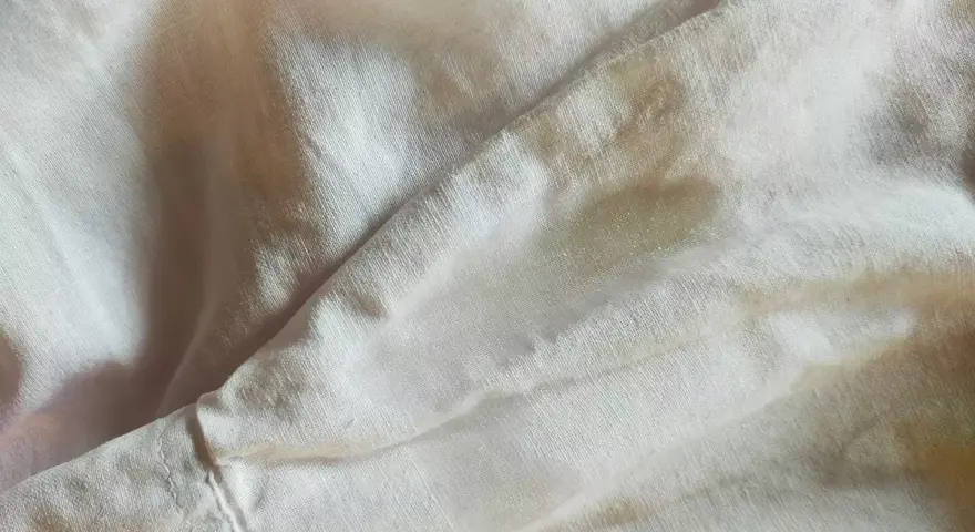 Tessuto di poliestere con macchie d'acqua visibili, che creano un effetto leggermente lucido e irregolare sulla superficie.