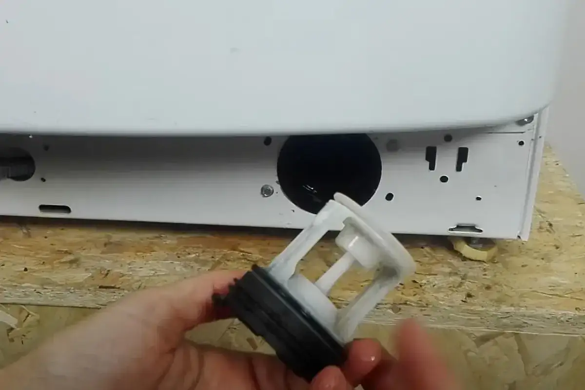 Filtro lavatrice estratto, pronto per la pulizia. Ricorda di controllare ogni quanto pulire filtro lavatrice per un bucato perfetto.
