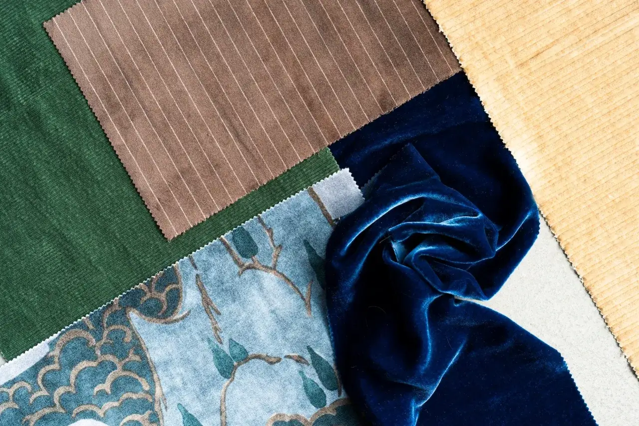 Tessuti diversi: velluto blu, velluto a coste verde e giallo, tessuto a righe marrone e tessuto stampato blu.