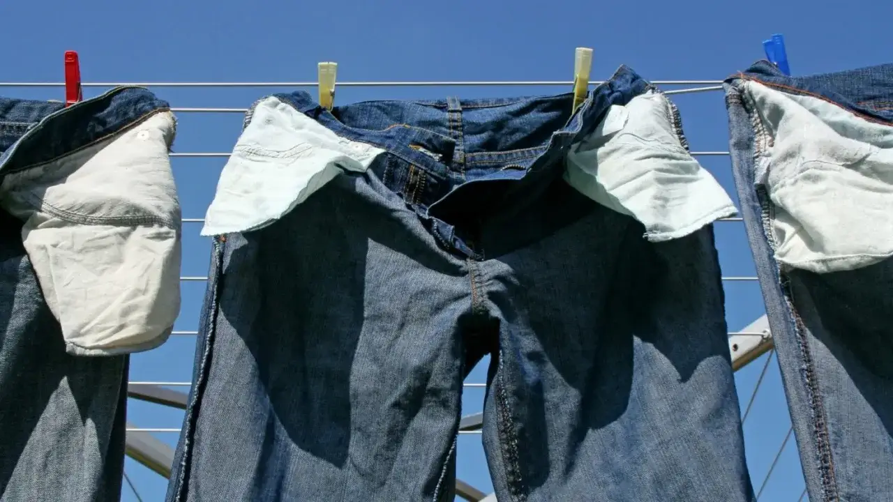 Jeans duri dopo lavaggio appesi ad asciugare al sole.