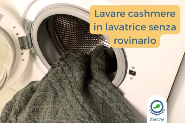 Un maglione di cashmere grigio viene inserito in una lavatrice. Impara come si lava il cashmere in lavatrice senza rovinarlo.