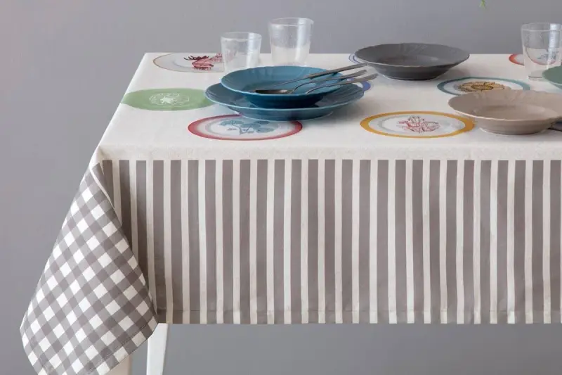 Tovaglia a righe e quadri con piatti colorati. Un'idea per sapere come smacchiare le tovaglie e mantenerle sempre perfette.