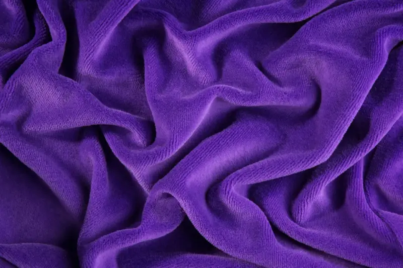 Tessuto di velluto a coste viola, morbido e drappeggiato. Scopri come lavare il velluto a coste per mantenerlo come nuovo.